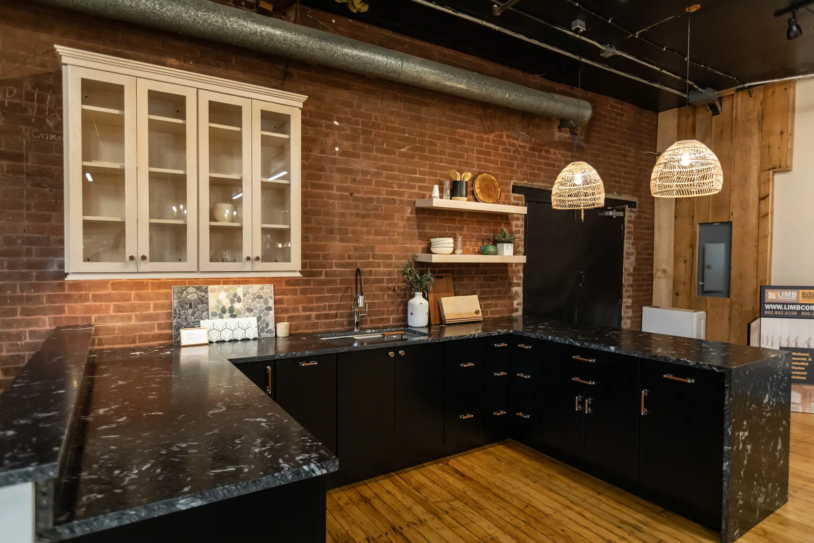 Dark cabinet kitchen with exposed brick wall