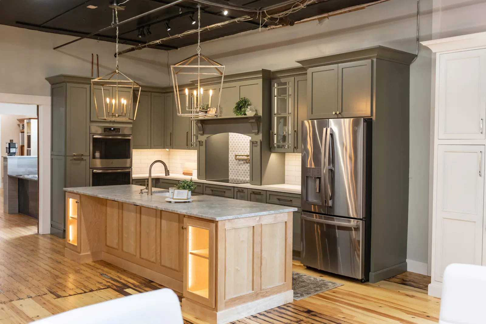 Sage green kitchen display with lit island